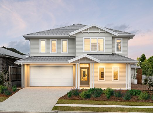 Modern two-story residential home with white and cream exterior, metal roof, double garage, illuminated windows at dusk, concrete driveway, and manicured front landscaping.