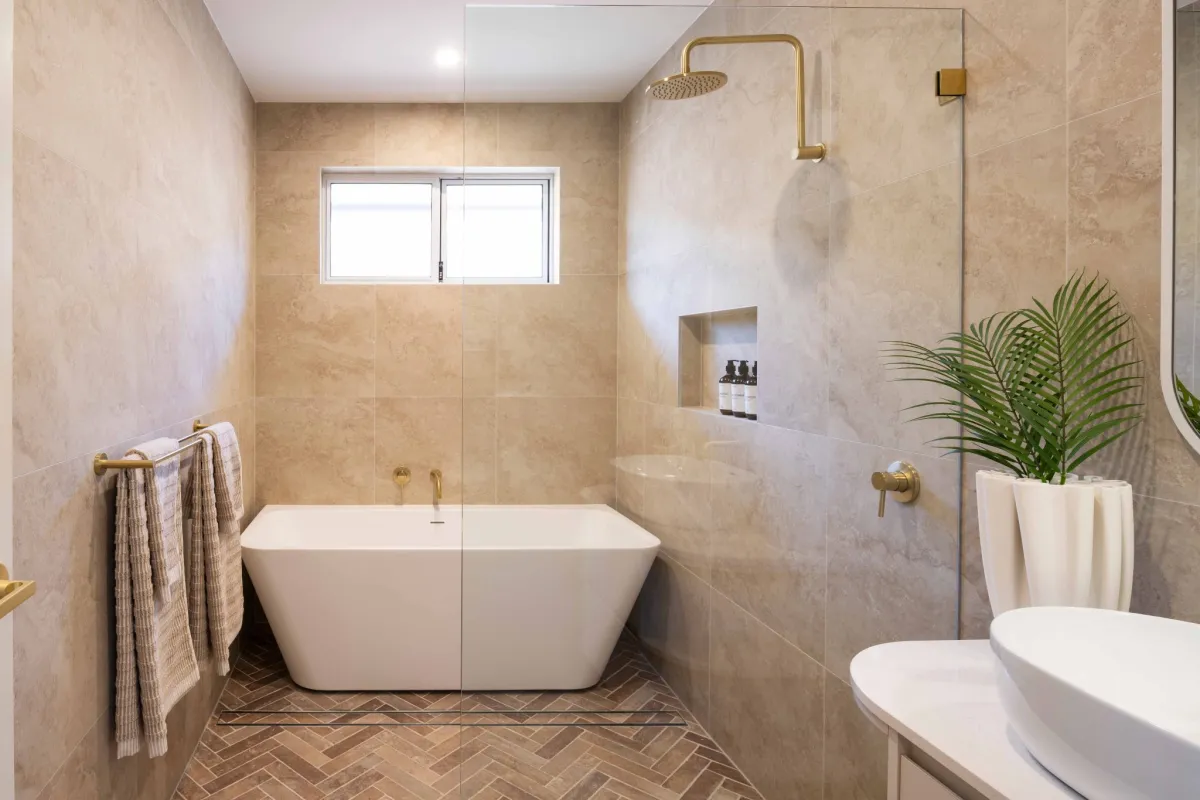 rectangular freestanding bath in a cream-coloured bathroom with marbled walls