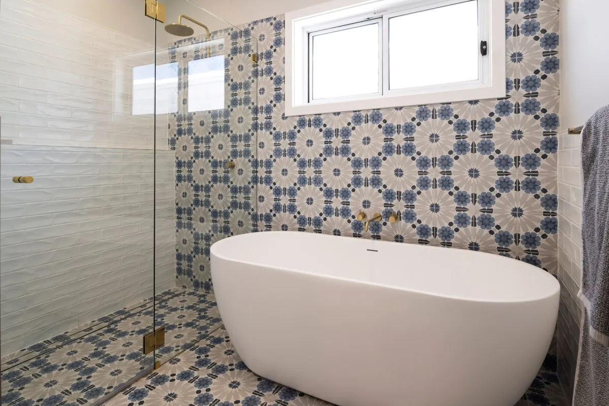 freestanding bath against a tiled feature wall and connected to a walk-in shower