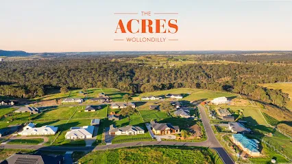 Aerial view of The Acres residential development in Tahmoor, showing sprawling green properties, homes, and landscaped grounds surrounded by native bushland and trees.