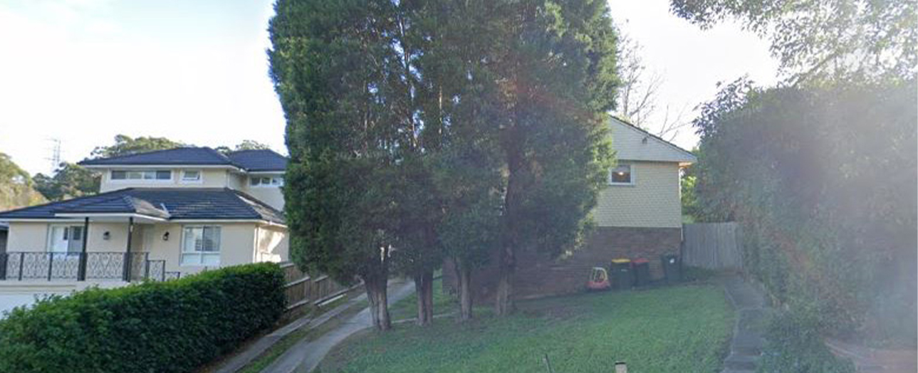 Dundas Valley residential street before development, showing two houses separated by tall mature trees and green lawn, with hedges and fencing along the properties.